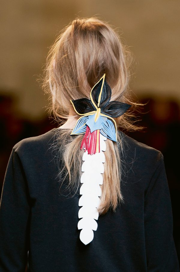 <b>Hair tropical</b> On aime ces cheveux délicatement rassemblés en queue de cheval fluide et attachés par une orchidée en cuir. La touche fleur bleue de l’été prochain. Défilé Fendi.