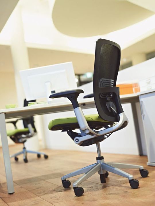 Une chaise de bureau à haut dossier procure un sentiment de sécurité et de stabilité. L'assise vert pomme dynamise l'aspect général des tons gris.