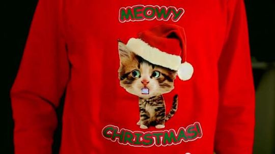 Le pull animé <b>Caroling Kitty Christmas</b> affiche un chat qui entonne des chants de Noël.